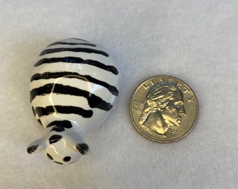 Pequeño gato de cerámica blanco con rayas negras