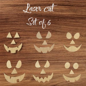 May include: Laser cut wooden pumpkin faces arranged in a set of six. Each face has a unique design, with triangular or oval eyes and various mouth shapes. The text "Laser cut Set of 6" is in the upper center.
