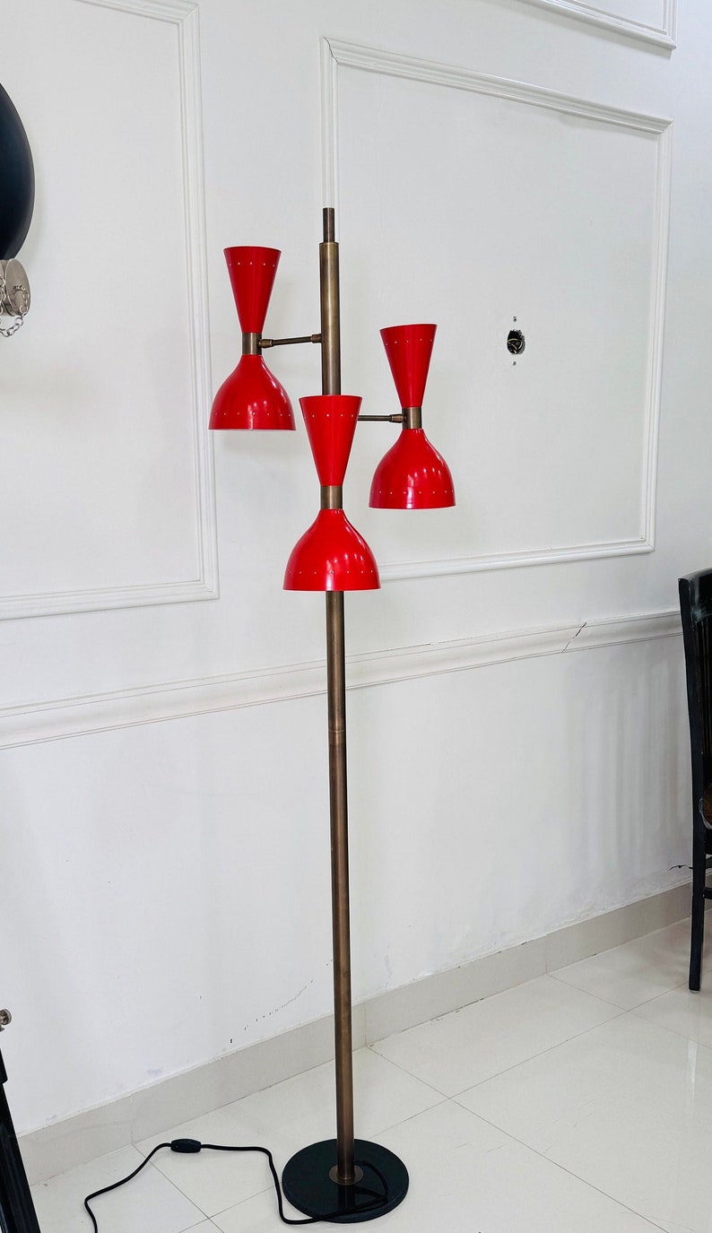 May include: A red and brass floor lamp with four adjustable shades. The lamp has a black base and a long cord.
