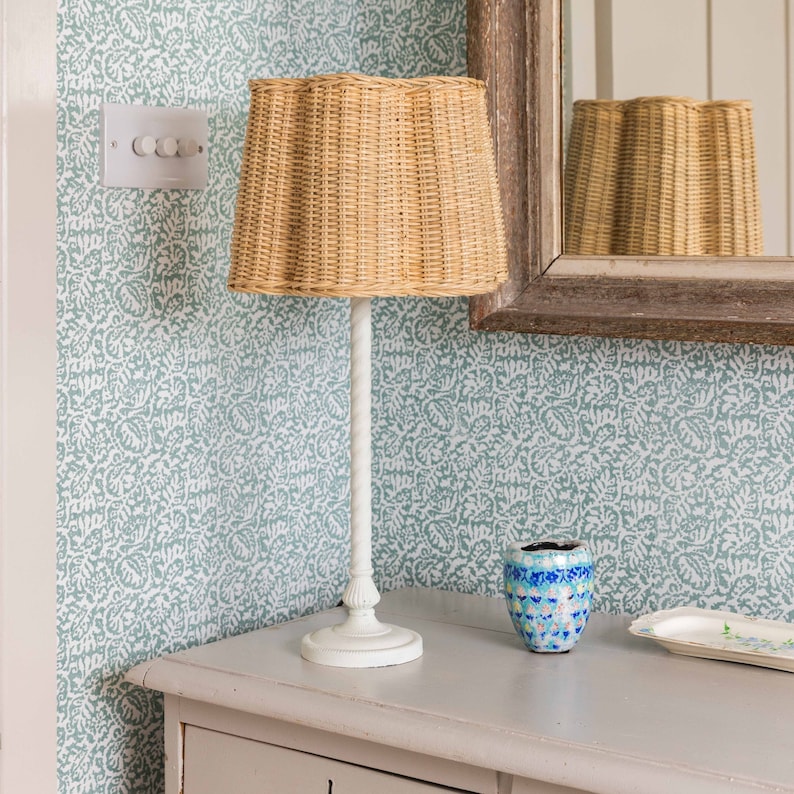 Clover Rattan Lampshade with a lamp.