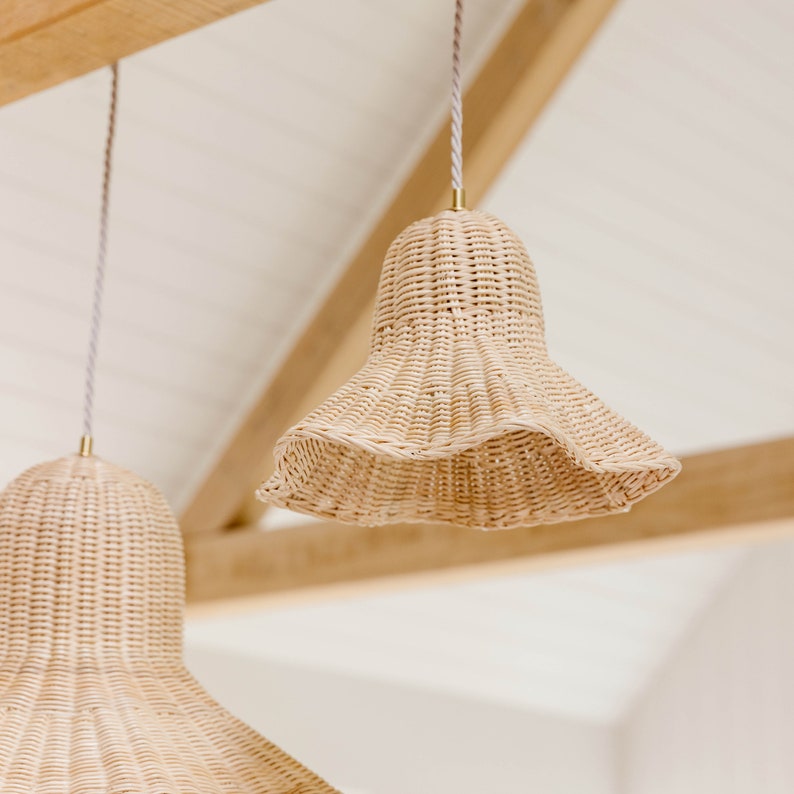 K&ouml;nnte beinhalten: Zwei geflochtene H&auml;ngeleuchten aus Weide h&auml;ngen an einer Holzdecke. Die Leuchten haben die Form von Glocken mit einem breiten, ausgestellten Boden.