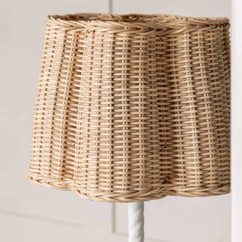 K&ouml;nnte beinhalten: Ein geflochtener Lampenschirm aus Weide in nat&uuml;rlicher beige Farbe. Der Lampenschirm hat einen gewellten Rand und ein geflochtenes Muster.