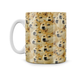 May include: White ceramic mug featuring a repeating pattern of Shiba Inu dog faces. The dog faces all have a slightly surprised expression and are looking at the viewer.