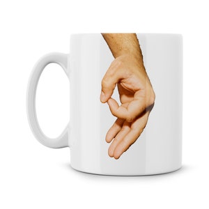 May include: White ceramic coffee mug with a hand making the "okay" gesture printed on the front.