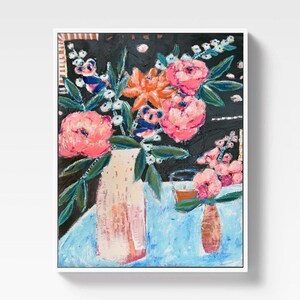 Op de afbeelding: Een abstract schilderij van bloemen in vazen. Het kunstwerk toont een grote vaas met roze bloemen en een kleinere vaas met roze bloemen. De achtergrond is zwart met een blauw tafelkleed. Het schilderij is ingelijst in een witte lijst.