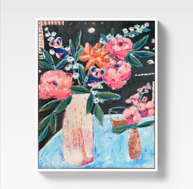 Op de afbeelding: Een abstract schilderij van bloemen in vazen. Het kunstwerk toont een grote vaas met roze bloemen en een kleinere vaas met roze bloemen. De achtergrond is zwart met een blauw tafelkleed. Het schilderij is ingelijst in een witte lijst.