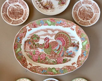 May include: Set of seven vintage ceramic plates featuring a brown and white floral pattern. The plates include a large oval platter with a turkey design, six smaller round plates with various floral designs, and a small round plate with a white center.