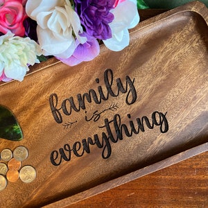 May include: A wooden tray with a dark brown stain. The tray has a quote engraved on it that reads "family is everything".