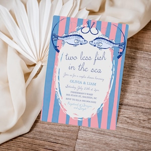 Può includere: Un invito a strisce blu e rosa su sfondo bianco. L'invito presenta due pesci che si fronteggiano con canne da pesca e ami. Il testo recita "Due pesci in meno nel mare" e include i dettagli per una festa di addio al nubilato per Olivia e Liam. L'evento è previsto per sabato 25 luglio alle 14:00 presso il Fisherman's Wharf, 305 State St, Raleigh, NC. RSVP a Ella al 919.904.5432. L'invito indica anche che la coppia è registrata su Amazon e Target.