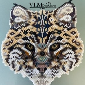 May include: A beaded portrait of a bobcat with a geometric pattern on its face. The bobcat has brown, black, white, and beige beads. The background is a light beige color.