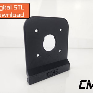 May include: A black 3D printed wall mount with a circular cutout and four screw holes. The mount has the text "CMS" printed on the bottom.
