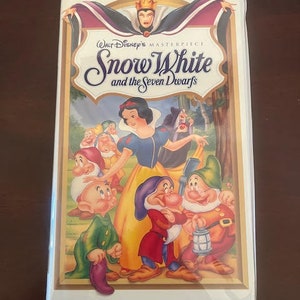 May include: A VHS tape featuring the classic Disney movie "Snow White and the Seven Dwarfs". The cover art features Snow White and the seven dwarfs, along with the Evil Queen.