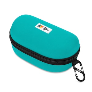 May include: Teal-colored, oval-shaped case with a black zipper and a black carabiner clip. A small white rectangular patch with a colorful logo is on the front. The case is designed to protect eyewear or small accessories.