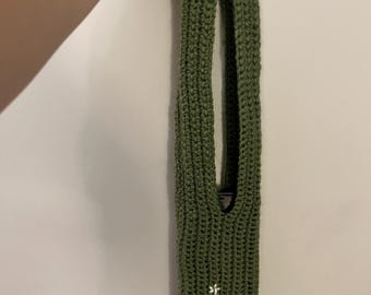 May include: Olive green crocheted wine bottle holder with a Christmas tree design embroidered in yellow and white. The holder has a long, open design to accommodate a wine bottle. The holder is handmade.