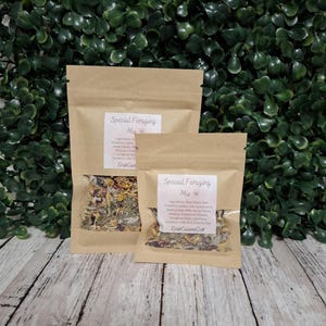 May include: Two brown kraft paper pouches containing a dried botanical foraging mix. Each pouch features a clear window displaying the contents and a white label printed with the text Special Foraging Mix and CrabCuisineCo.