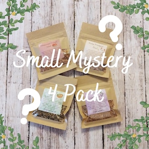 May include: Four small, rectangular, light brown paper pouches containing dried food mixes. Each pouch features a white label with printed text and a clear window showing the contents. The text includes Pomegranate Orchard Salad, Nutty Breakfast Bowl, and CrabCuisineCo.