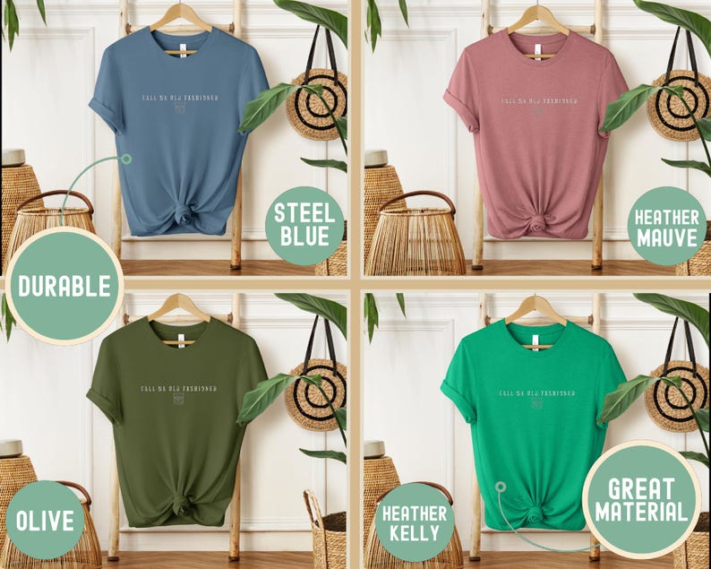 May include: Four t-shirts in steel blue, heather mauve, olive, and heather kelly green, each with the text "FALL SA BLE FASHIONED" in white. The shirts are displayed on wooden hangers, with the words "DURABLE" and "GREAT MATERIAL" in circles.