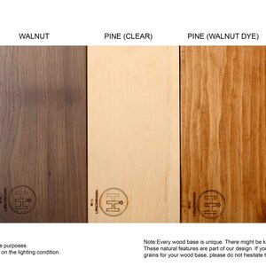 May include: Five wooden samples are displayed, including Maple, Walnut, Pine (Clear), Pine (Walnut Dye), and Pine (Espresso Dye). The colours range from light beige to dark brown. The text at the bottom states that wood colour may vary depending on lighting.