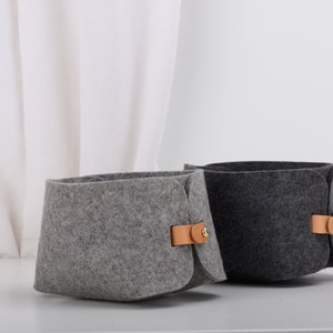 May include: Two felt storage baskets with leather handles. One basket is gray and the other is dark gray.