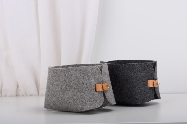 May include: Two felt storage baskets with leather handles. One basket is gray and the other is dark gray.