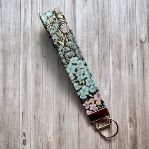 Llavero de pulsera con diseño floral oscuro