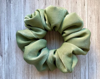 May include: A green satin scrunchie for hair.