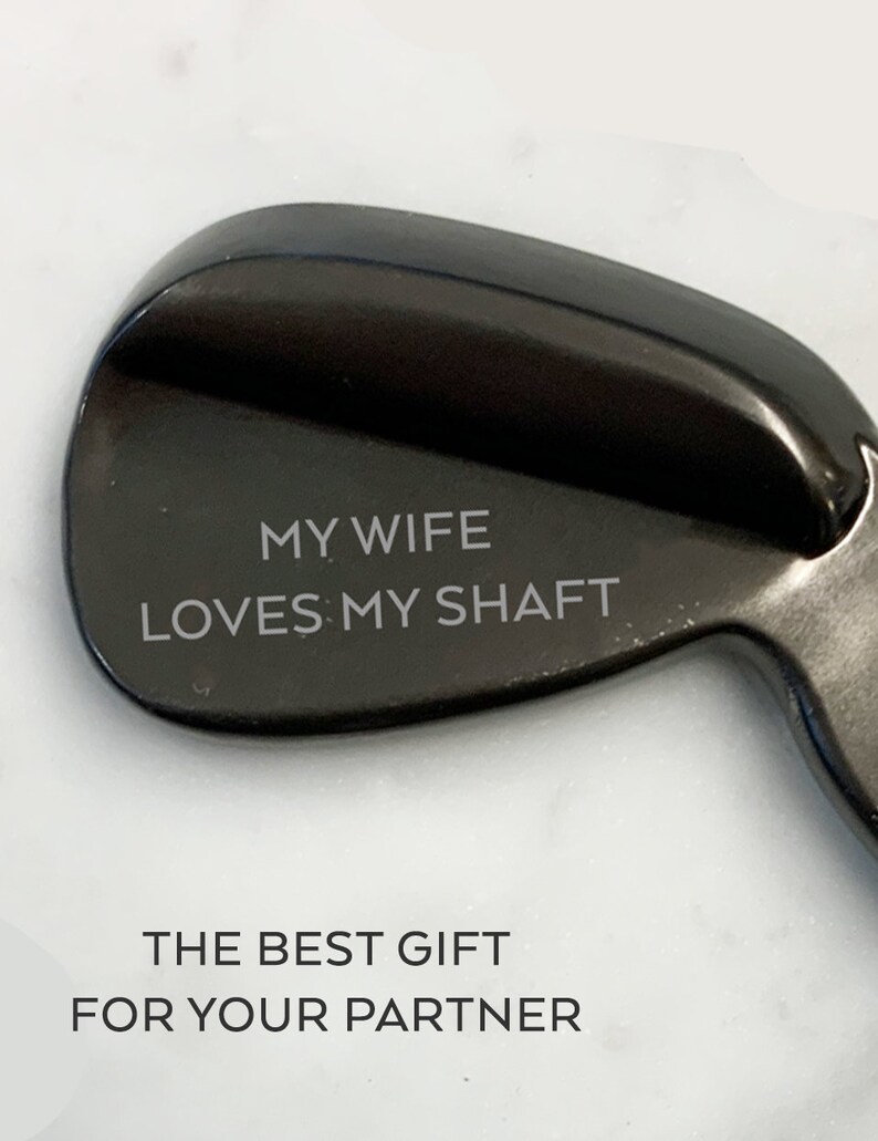 May include: A black golf club head with the text "MY WIFE LOVES MY SHAFT" engraved on it. The best gift for your partner.