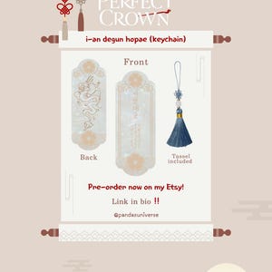May include: An i-an degun hopae keychain featuring a rectangular plaque with a dragon illustration on the back and Korean text on the front. The set includes a blue tassel with a decorative knot and a small white bead, presented on a scroll display.