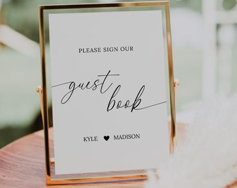 May include: A gold-framed sign with the text "Please sign our guest book" and the names "Kyle" and "Madison" with a heart symbol between them.