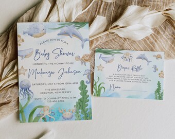May include: A blue and green baby shower invitation with a watercolor illustration of sea creatures, including a whale, dolphin, jellyfish, seahorse, crab, and octopus. The invitation includes the text "Please join us for a Baby Shower honoring the mommy-to-be Mackenzie Johnson Saturday, May 5 from 12pm-4pm The Brassrail Hoboken, New Jersey RSVP to Donna by April 15th: 123-456-6789". A separate card with a blue and green watercolor illustration of sea creatures, including a whale, octopus, seahorse, and starfish, includes the text "Duper Riffle A bundle of joy is on the way and we're sure hoping you will play Please bring a pack of diapers in any size for a chance to win a special price! Name".
