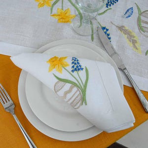 Può includere: Una tazza di ceramica bianca con un manico nero e la scritta "But First, Coffee" in nero, con un carattere a mano. La tazza è su una superficie bianca.