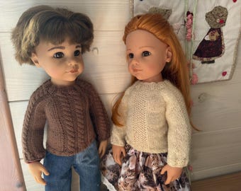 May include: Two dolls are featured, one with brown hair and a brown cable-knit sweater, blue jeans. The other doll has red hair, a cream-colored sweater, and a skirt with a cat print. They stand side by side.