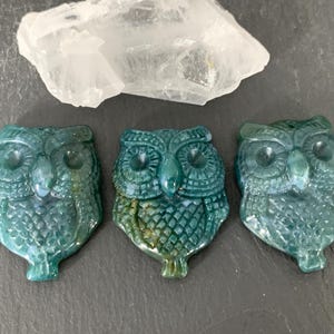 May include: A white ceramic mug with a black handle and the text "But First, Coffee" in a black, bold font. The mug is sitting on a wooden surface.