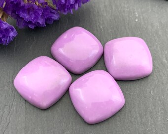 Op de afbeelding: Vier lichtpaarse, vierkante cabochons met afgeronde hoeken liggen op een grijze ondergrond. De cabochons hebben een glanzende afwerking. Paarse droogbloemen bevinden zich in de linkerbovenhoek.