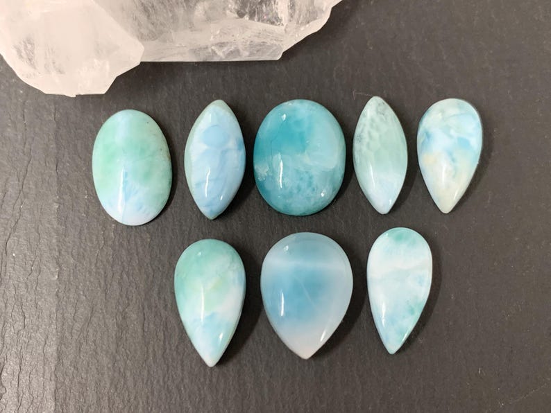 Peut inclure: Une collection de huit pierres pr&eacute;cieuses cabochon bleues et vertes avec un motif marbr&eacute;. Les pierres pr&eacute;cieuses sont de formes vari&eacute;es, notamment ovale, goutte d'eau et ronde.
