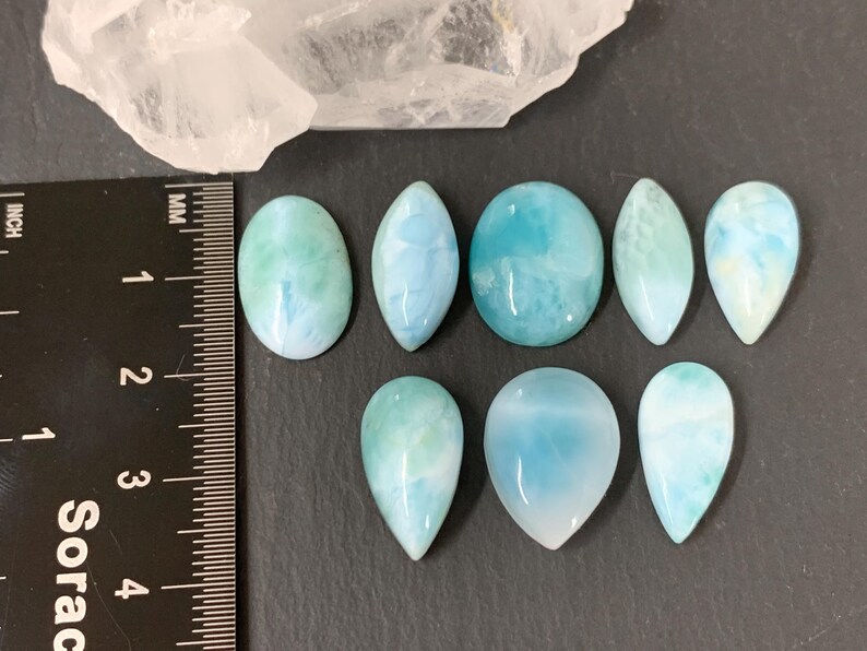 Peut inclure: Neuf pierres pr&eacute;cieuses en cabochon de diff&eacute;rentes formes et tailles, notamment ovales, en forme de larme et rondes. Les pierres sont de couleur bleu clair avec des tourbillons et des motifs blancs et verts.