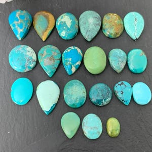 May include: Assortment of turquoise cabochons in various shades of blue and green, including teardrop and oval shapes.