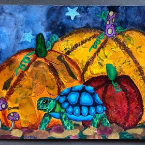 Pode incluir: Uma pintura em aquarela de três abóboras e uma tartaruga. As abóboras são laranja e amarelas com caules verdes. A tartaruga é azul e verde com uma carapaça marrom. O fundo é azul escuro com estrelas brancas.