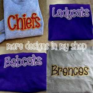 Pu&ograve; includere: Quattro felpe con nomi di squadre ricamati: "Chiefs", "Ladycats", "Bobcats" e "Broncos". Le felpe sono grigie e viola. &Egrave; visibile anche il testo "more designs in my shop".