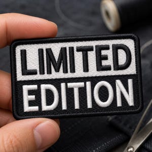 May include: A rectangular embroidered patch featuring a two-tone design. The top half has a white background with the black text LIMITED, and the bottom half has a black background with the white text EDITION. The patch has a black stitched border.