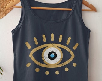 May include: A dark blue tank top with a gold evil eye graphic. The eye is outlined in gold and has a blue iris and white pupil. The graphic has a distressed look.