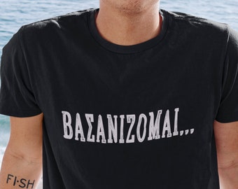 May include: A man wearing a black t-shirt with the text "BAZANIZOMAI..." printed in white. He has a tattoo on his arm that says "FISH".