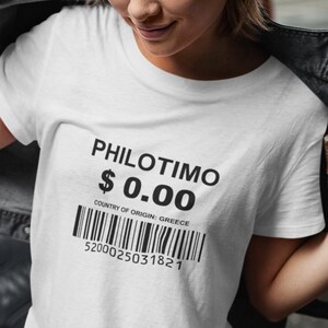 Puede incluir: Camiseta blanca con texto negro que dice "PHILOTIMO $0.00" y un código de barras que dice "COUNTRY OF ORIGIN: GREECE 5200025031821".
