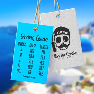 Peut inclure: &Eacute;tiquette de guide des tailles bleue et blanche avec le texte "Sizing Guide" et un tableau des tailles unisexes en centim&egrave;tres. L'&eacute;tiquette est suspendue &agrave; une ficelle. Une &eacute;tiquette blanche avec un graphique de cr&acirc;ne noir et le texte "Tees for Greeks to the Bone" est suspendue &agrave; une ficelle au-dessus de l'&eacute;tiquette bleue.
