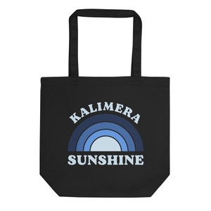 Peut inclure: Sac fourre-tout noir avec un motif arc-en-ciel bleu et blanc et le texte "Kalimera Sunshine".