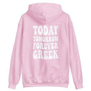 K&ouml;nnte beinhalten: Rosa Kapuzenpullover mit dem Text "TODAY TOMORROW FOREVER GREEK" in Wei&szlig; auf der R&uuml;ckseite.