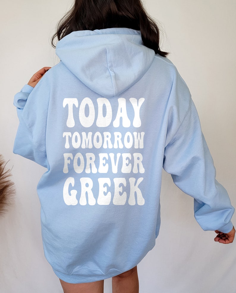 K&ouml;nnte beinhalten: Ein hellblauer Kapuzenpullover mit dem Text "TODAY TOMORROW FOREVER GREEK" in Wei&szlig; auf der R&uuml;ckseite.