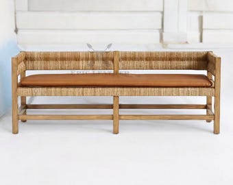 May include: A wooden bench with a woven rattan back and seat. The bench has a brown leather cushion and a lower shelf.