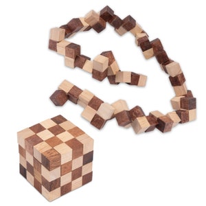 Könnte beinhalten: Ein Holzpuzzle mit einem Schachbrettmuster. Das Puzzle besteht aus kleinen Würfeln, die auf verschiedene Arten angeordnet werden können. Das Puzzle hat die Form eines Würfels und ist aus hellem und dunklem Holz gefertigt.