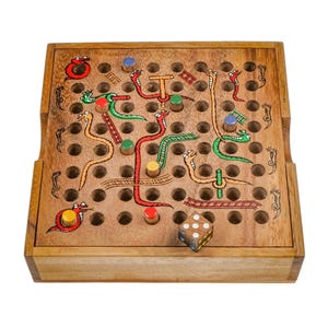 Puede incluir: Juego de mesa de Serpientes y Escaleras de madera con serpientes, escaleras y fichas de colores. El tablero es cuadrado con una cuadrícula de agujeros, e incluye un dado. El juego es de madera marrón claro.